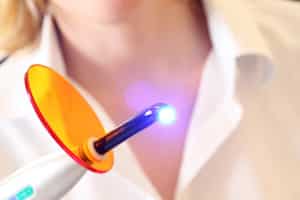 Handheld Dental Laser Held by Female Dentist
