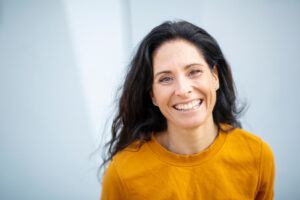 Woman smiling in mustard top